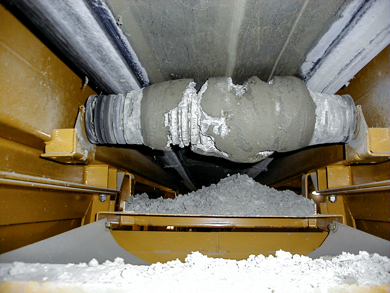 Return roll covered in material carryback on a belt conveyor.