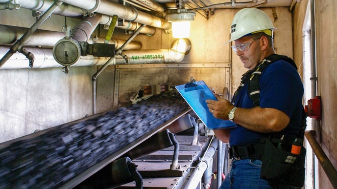 Consultant observing belt conveyor performance.