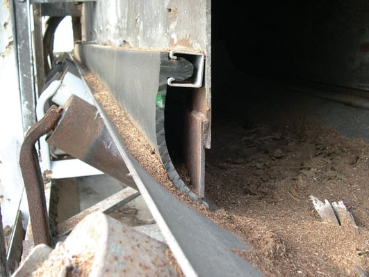 A sealing strip clamped to the outside of the chute and curing under the steel into the inside of the chutewall.