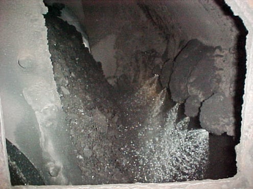 Looking down into a tranfer chute from the top head pulley you can see a dust suppression system spraying the coal.