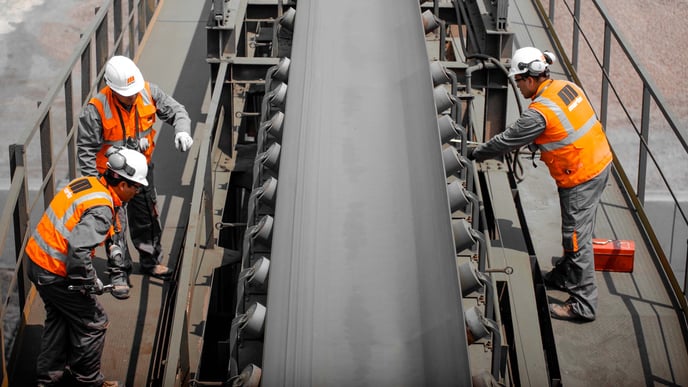 Technicians inspecting a belt conveyor.