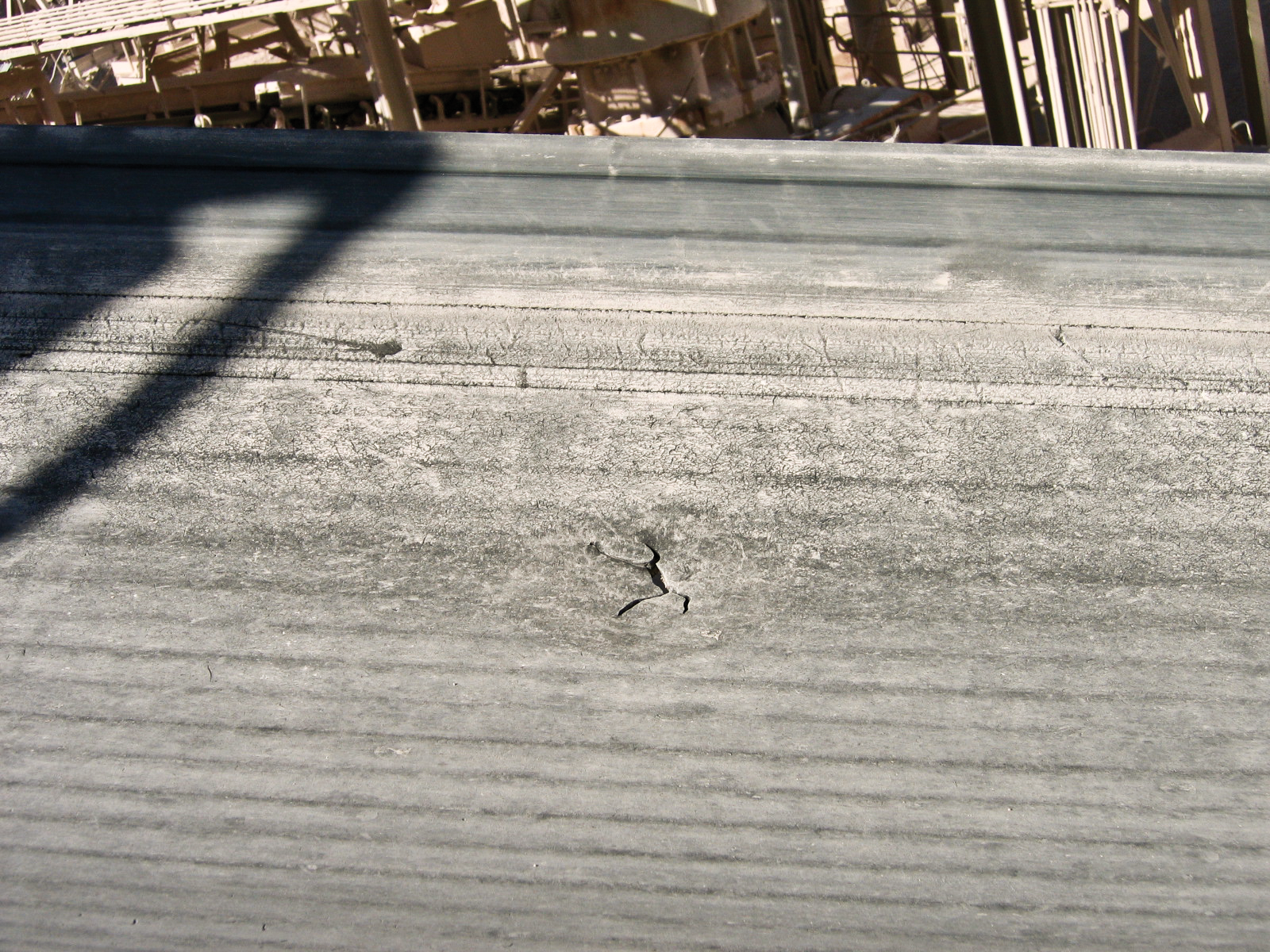 A cracked hole appears on the surface of a conveyor belt.