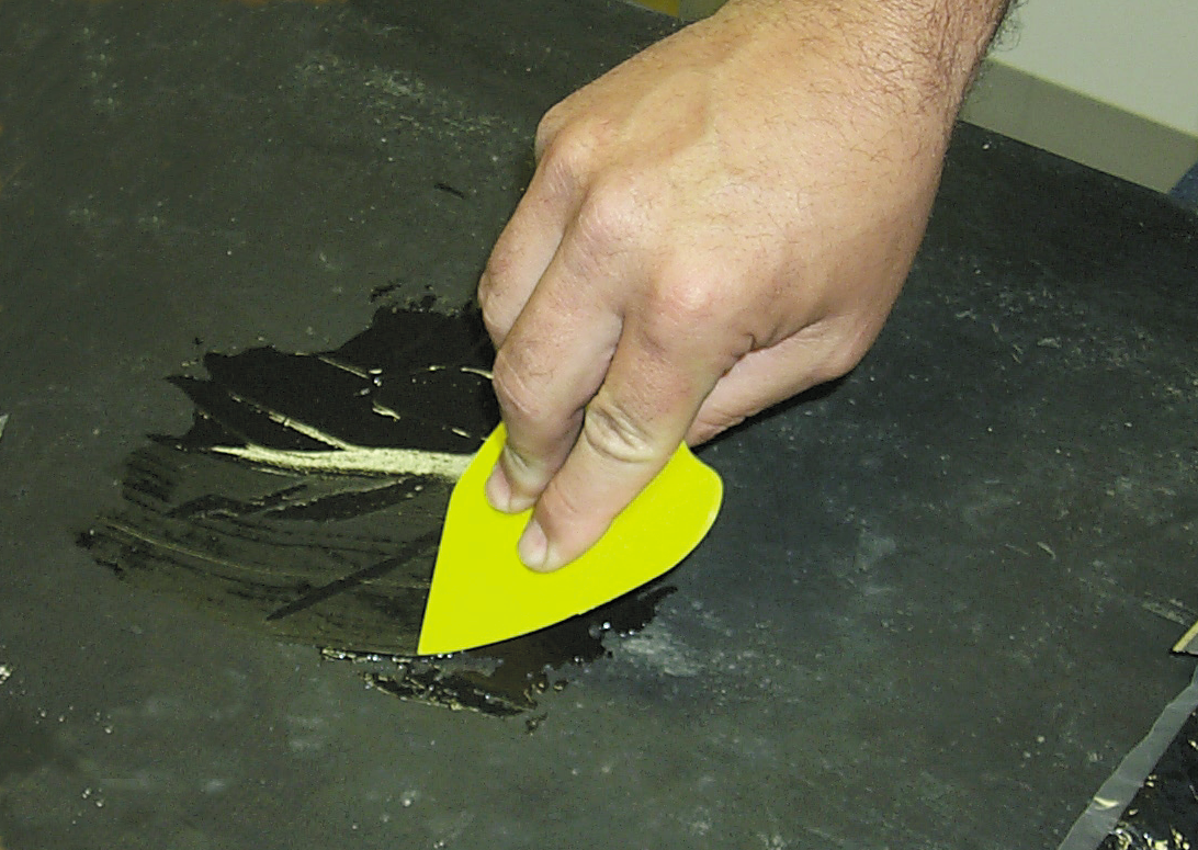 Applying adhesive to repair a damaged belt