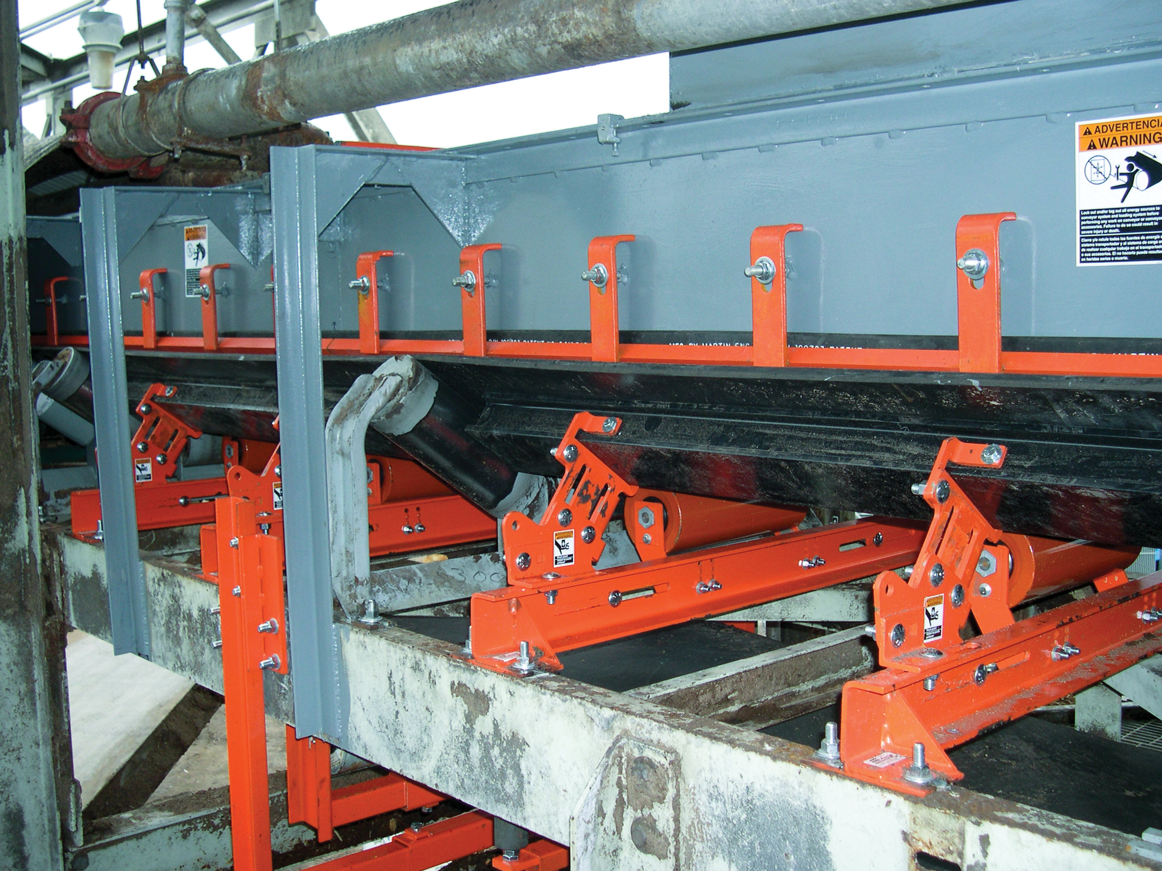 Belt support cradles and idlers in a belt conveyor transfer point.