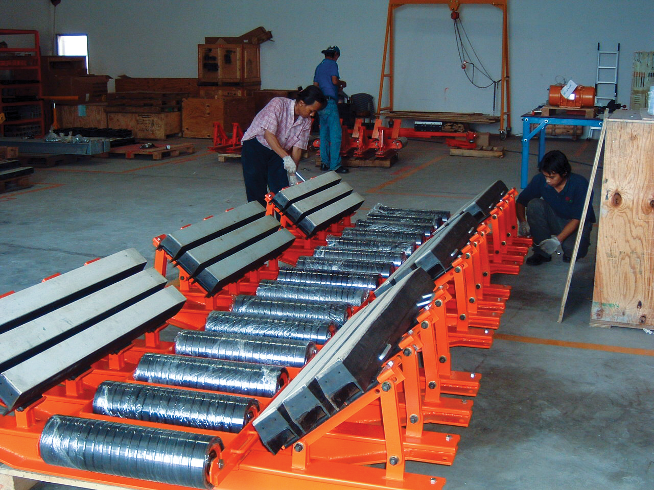 Belt conveyor cradles with bars and rollers.