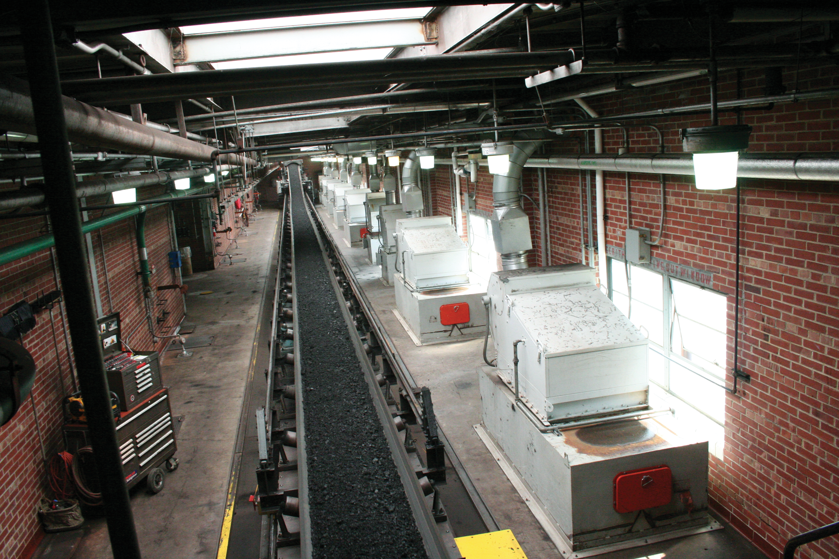 Several dust collectors are lined up in row on a tripper floor of a power plant.