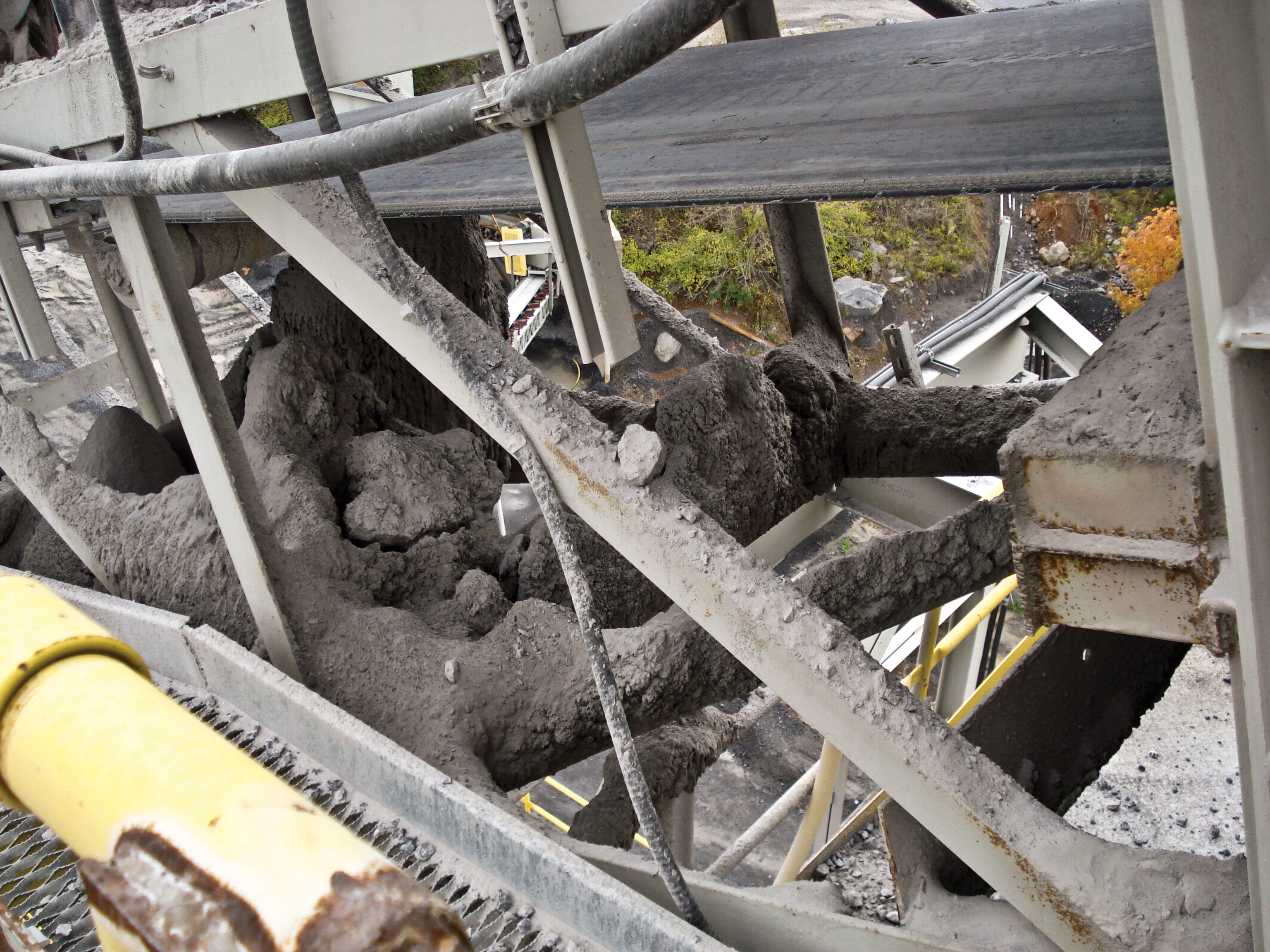 Fugitive material spilled on belt conveyor structure. 