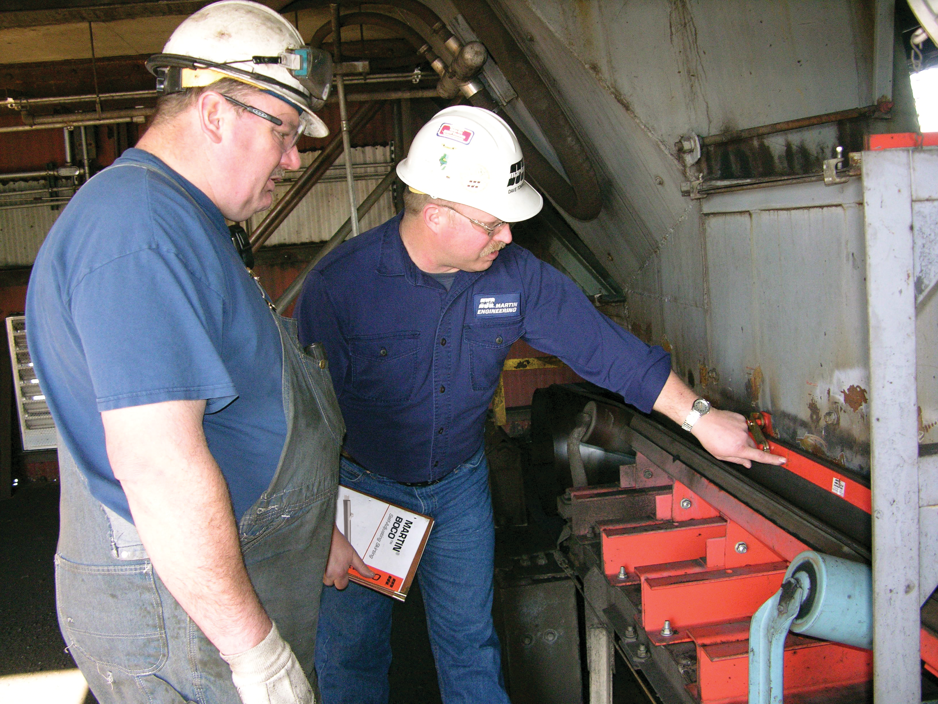 Conveyor expert discusses a belt conveyor system with a worker.