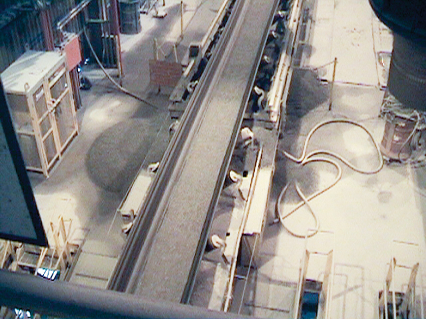 Material spillage is seen along the sides of a belt conveyor.